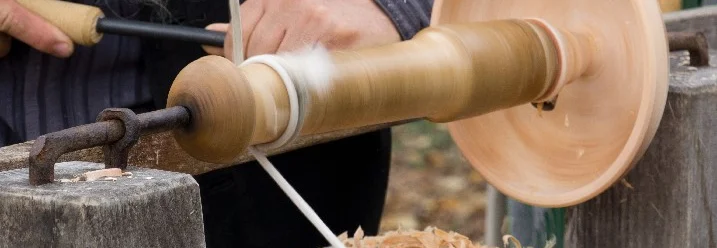 Person bearbeitet Holz mit Drechselbank